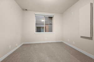 Carpeted empty room with baseboards