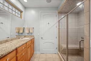 Bathroom featuring a shower stall, vanity, and light tile patterned floors
