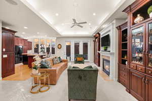Living area featuring a high end fireplace, recessed lighting, ceiling fan, and a tray ceiling