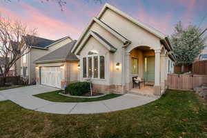 View of front of home featuring concrete driveway, roof with shingles, an attached garage, stucco siding, and a gate