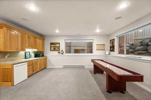 Rec room with light carpet, recessed lighting, and a baseboard heating unit