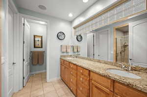 Full bath with double vanity, a stall shower, light tile patterned floors, and recessed lighting