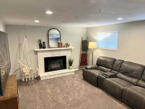 Carpeted living area with recessed lighting and a fireplace