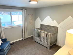 Bedroom featuring a nursery area and carpet floors