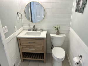 Bathroom featuring vanity, a wainscoted wall, and wooden walls