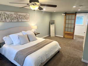 Bedroom featuring a barn door, carpet, recessed lighting, and a ceiling fan
