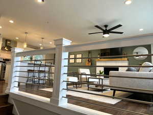 Living area featuring dark wood-style floors, recessed lighting, ceiling fan, and a brick fireplace
