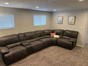 Carpeted living area featuring recessed lighting and baseboards