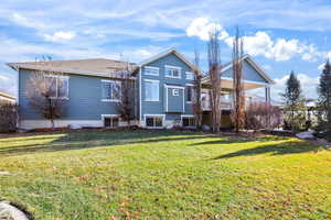 Rear view of house with a yard and a balcony