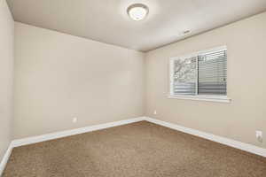 Carpeted empty room with baseboards