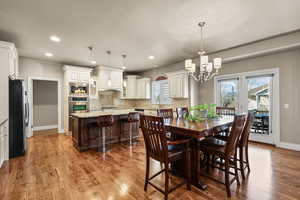 Dining room with recessed lighting, light wood-type flooring, and a chandelier