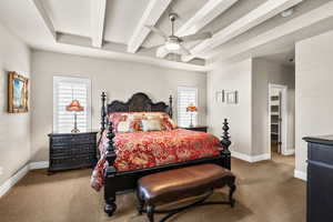 Bedroom featuring beamed ceiling, carpet floors, and a ceiling fan
