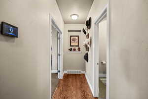 Hall featuring dark wood floors and baseboards