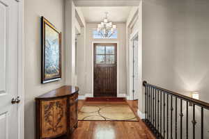 Entrance foyer with a chandelier and wood finished floors