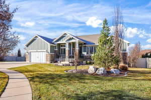 Craftsman house featuring board and batten siding, covered porch, and concrete driveway