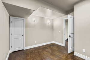Bonus room with baseboards and concrete floors