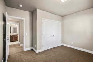 Unfurnished bedroom featuring a closet and carpet