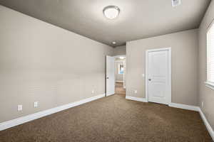 Unfurnished bedroom with carpet flooring and baseboards