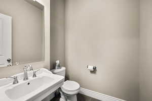 Half bath with a sink and tile patterned flooring
