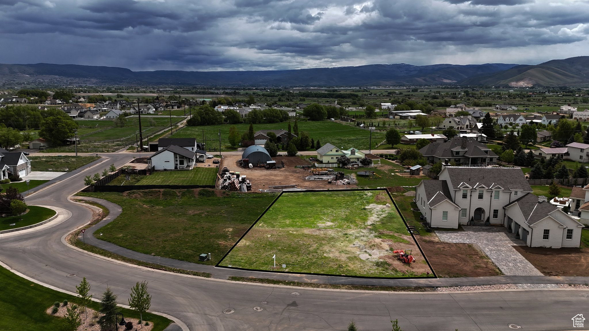 Aerial perspective of suburban area featuring property boundaries highlighted and mountains