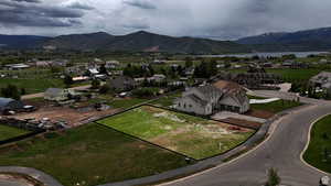 Aerial perspective of suburban area featuring property boundaries highlighted and a mountain backdrop