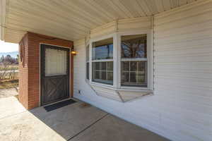 Doorway to property featuring brick siding