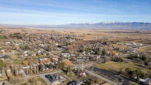 Aerial view of property and surrounding area featuring a mountainous background
