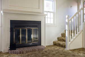 Detailed view of carpet and a brick fireplace
