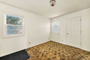 Carpeted spare room featuring baseboards