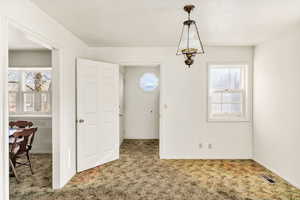 Dining space featuring carpet and baseboards