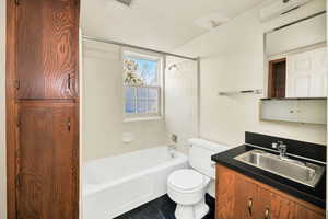 Bathroom with vanity, shower / washtub combination, and dark tile patterned flooring