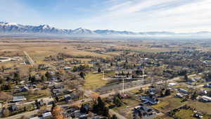 Aerial view of property and surrounding area featuring a mountainous background and property parcel outlined