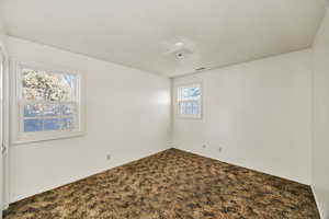 Unfurnished room featuring carpet flooring and a textured ceiling