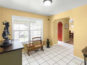 Living area featuring arched walkways and light tile patterned floors