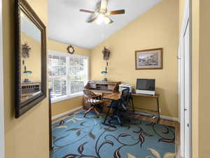 Home office featuring lofted ceiling, wood finished floors, and ceiling fan