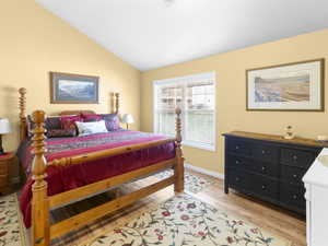 Bedroom featuring light wood-style flooring and lofted ceiling