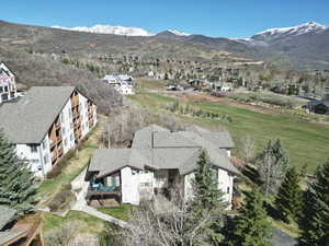 Aerial view of property and surrounding area featuring a mountain backdrop