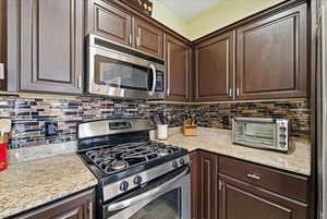 Kitchen with stainless appliances and updated backsplash.