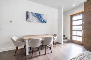 Dining area with stairway, wood-type flooring, and recessed lighting