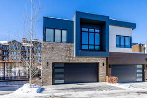 Contemporary home featuring stone siding and an attached garage