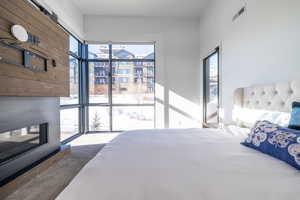 Bedroom featuring a glass covered fireplace