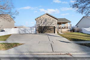 View of front of home with driveway, a porch, stairway, and brick siding