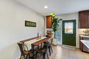 Dining room with light tile patterned flooring and recessed lighting