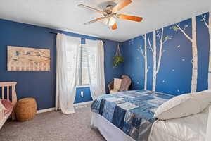 Bedroom featuring a textured ceiling, carpet floors, and a ceiling fan