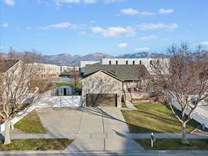 View of front facade with concrete driveway, a mountain view, a front lawn, and a garage
