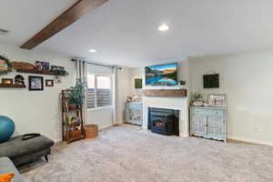 Carpeted living room with a wood stove and recessed lighting