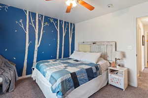 Carpeted bedroom with a ceiling fan