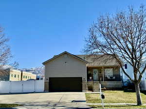 View of front of home featuring a gate, driveway, a porch, a garage, and brick siding