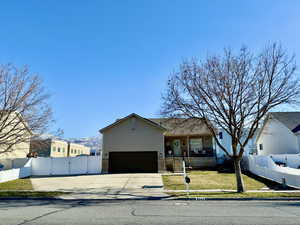 View of front of house featuring a gate, concrete driveway, and brick siding