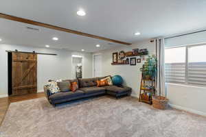 Living room with a barn door and recessed lighting
